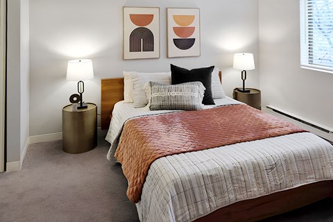 made bed with two nightstands and wall art