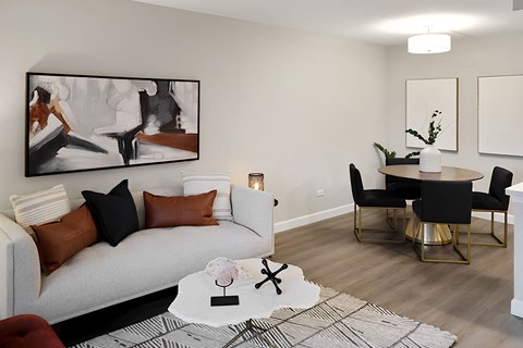 A living room with a white couch, a coffee table, and a painting on the wall.