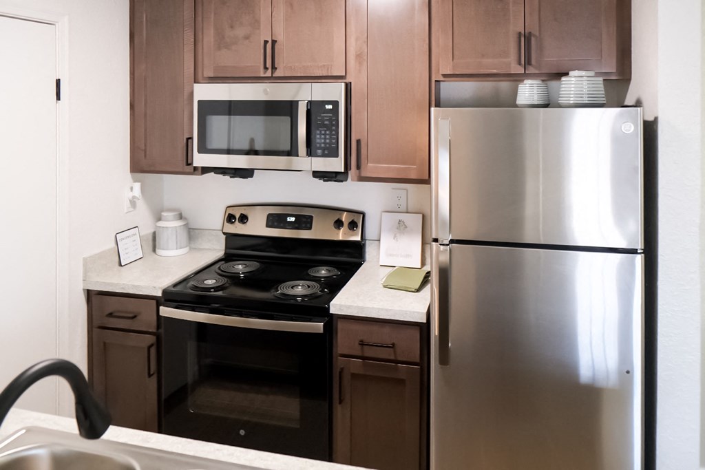 a kitchen with wooden cabinets and stainless steel appliances