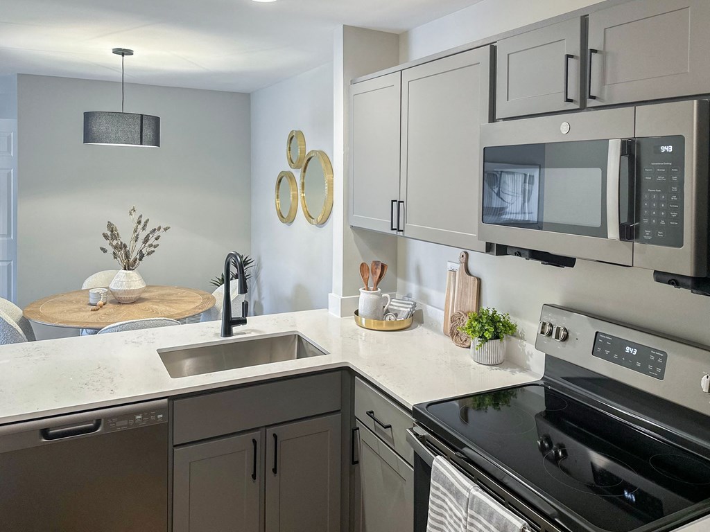 a kitchen with gray cabinets and stainless steel appliances