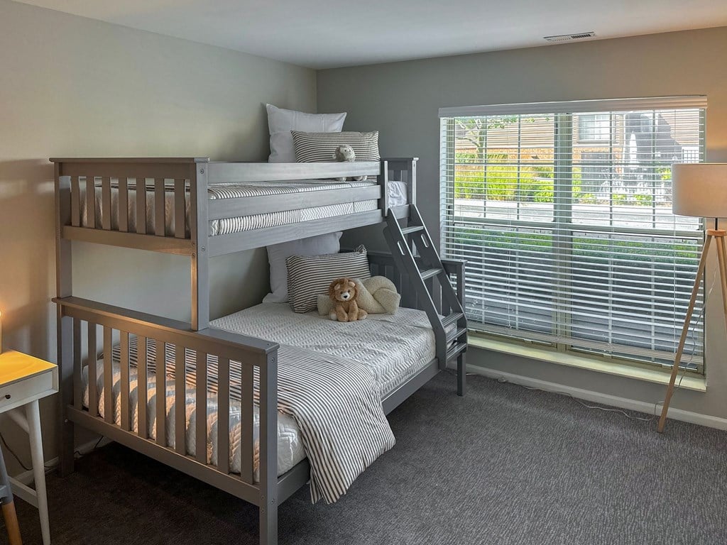bunk beds in a carpeted bedroom with large windows
