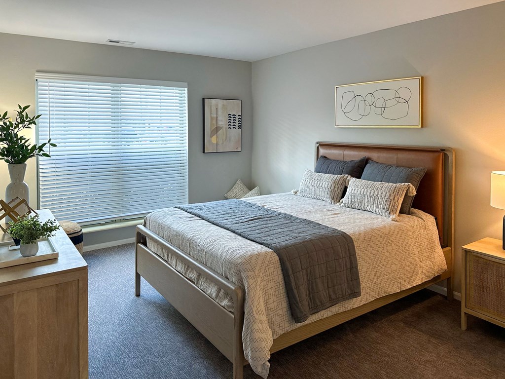 a bedroom with a large window and a large bed