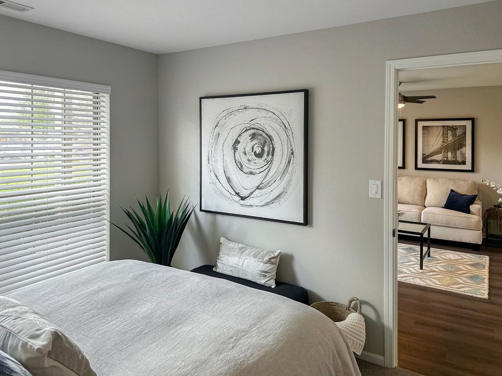 a bedroom with a bed and a window with blinds