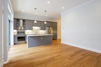 A modern kitchen with wooden floors and a large island.