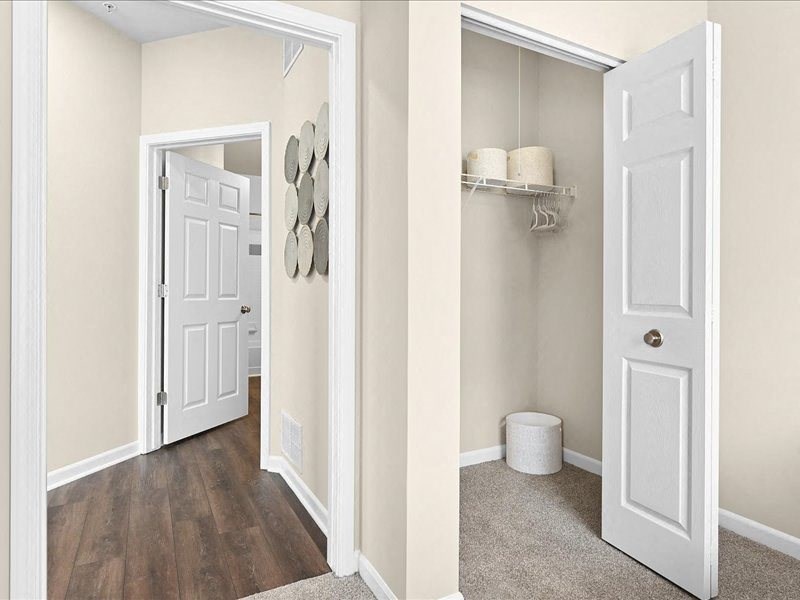 bedroom closet and a hallway leading to a bathroom