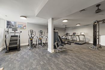 A gym with treadmills, exercise bikes, and other equipment.