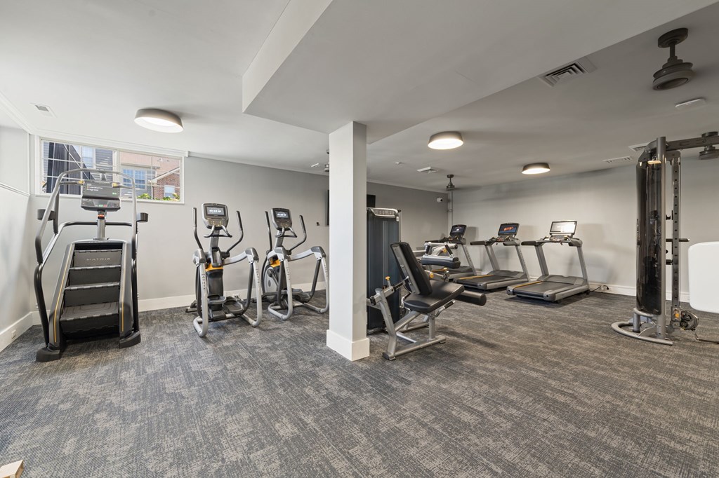 A gym with treadmills, exercise bikes, and other equipment.
