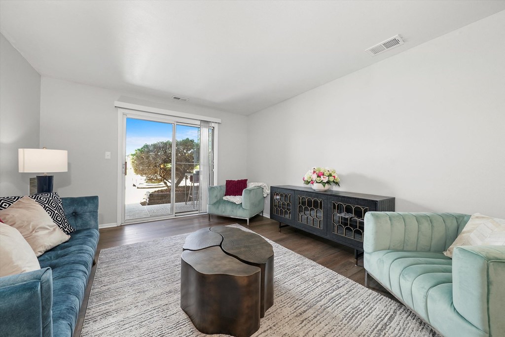 a living room with blue couches and a large sliding glass door