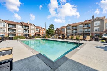 A swimming pool in front of apartment buildings.