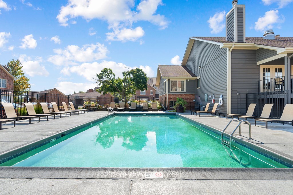 A swimming pool with a slide and sun loungers.