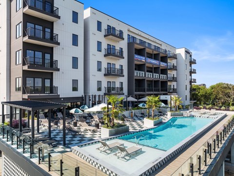 A large white building with a pool in front.