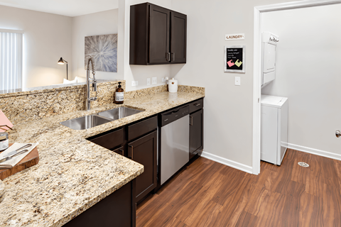 A kitchen with a granite counter top and a sink.