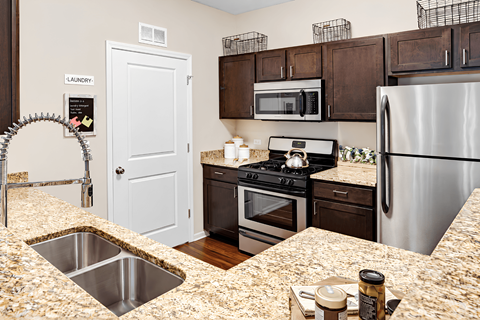 A kitchen with granite countertops and stainless steel appliances.