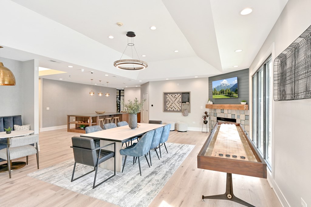 shuffleboard and a large dining table in the Farmington Lakes clubroom