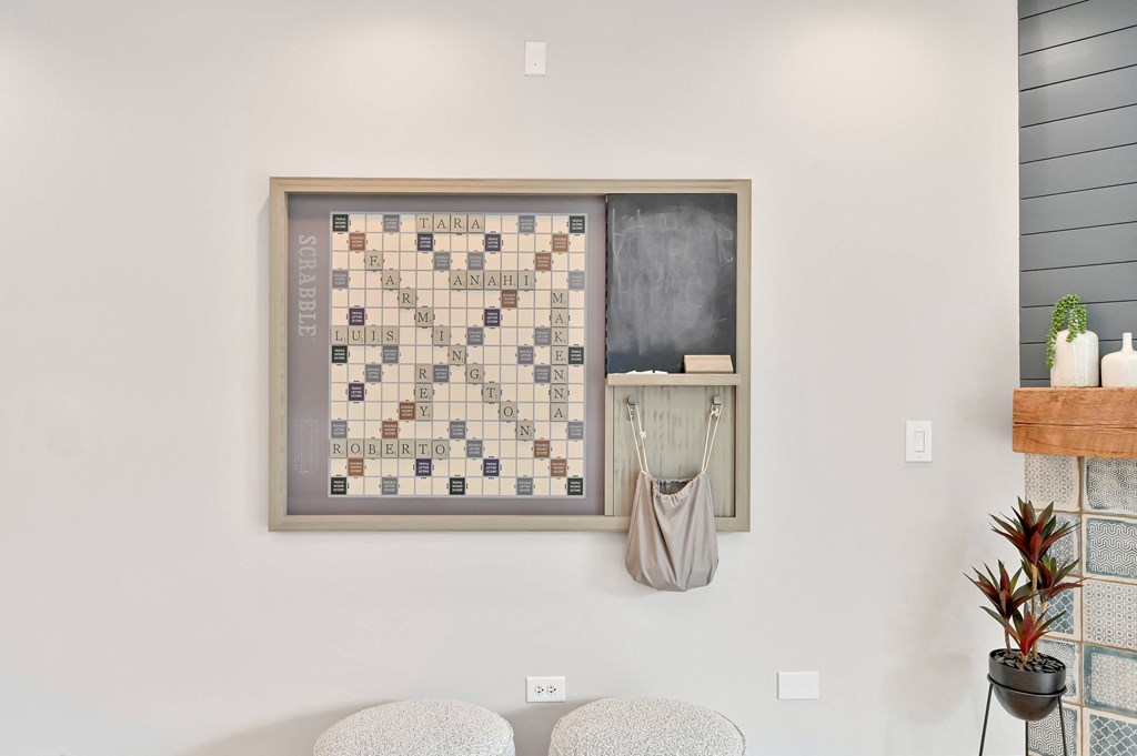 scrabble art piece mounted on a beige wall