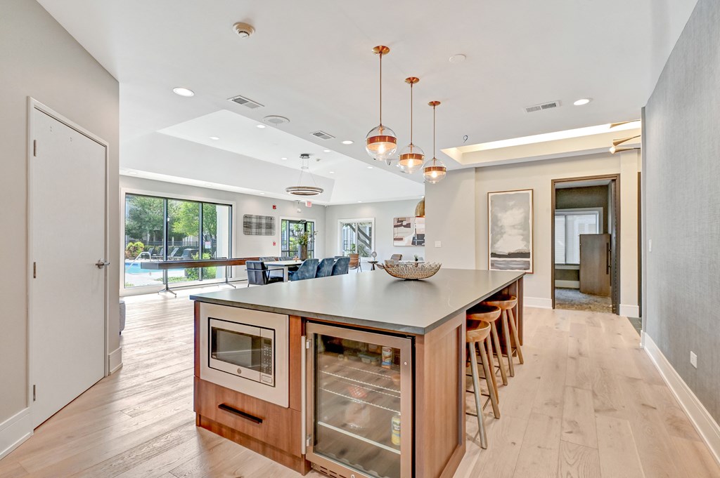 microwave and mini fridge built in to a large island with seating