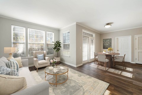 A living room with a grey couch, a coffee table, and a dining table with chairs.