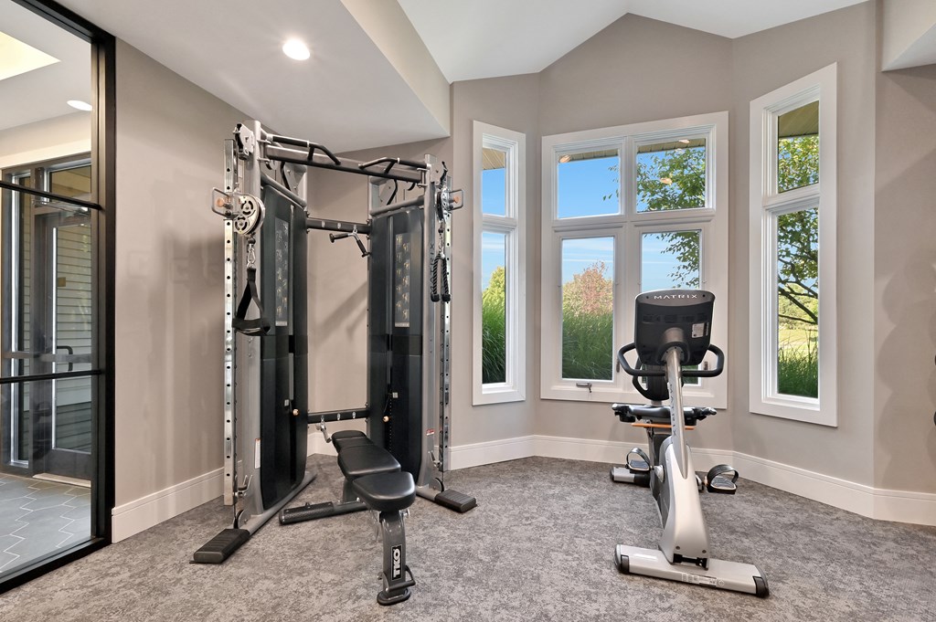 multi-station weight machine next to a stationary bike in Farmington Lakes fitness center