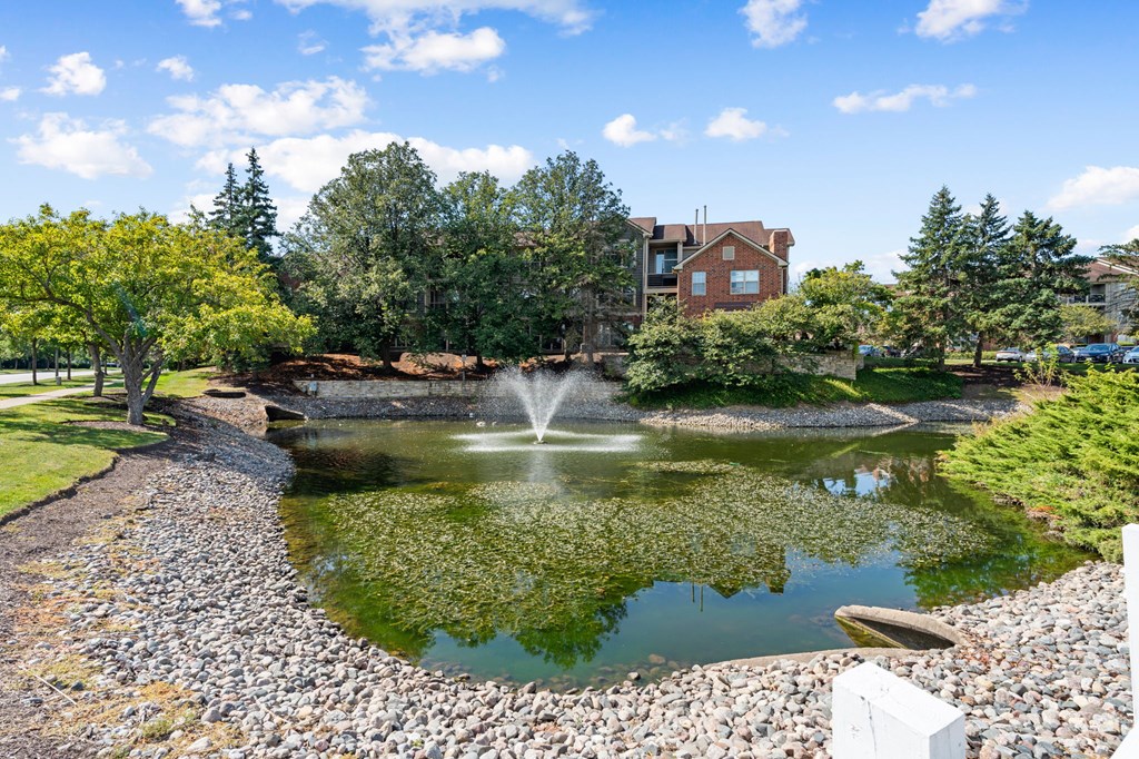 A pond with a fountain in the middle of it.