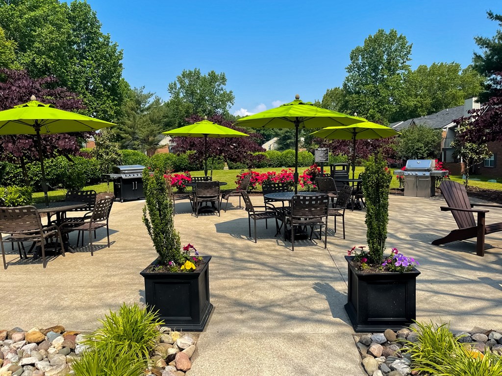 a patio with tables and chairs and umbrellas