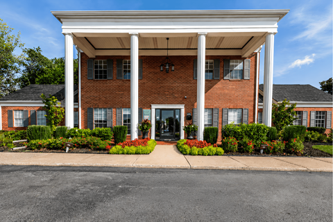 A red brick building with a white roof and pillars.