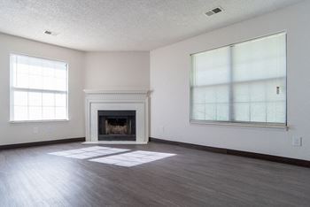 spacious living room with a fireplace and large windows