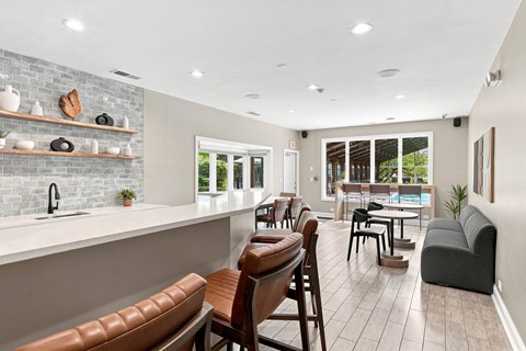 A modern kitchen with brown leather chairs and a white countertop.