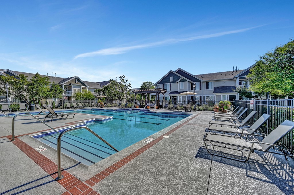 outdoor lounge chairs on a sundeck next to Farmington Lakes resort-style swimming pool