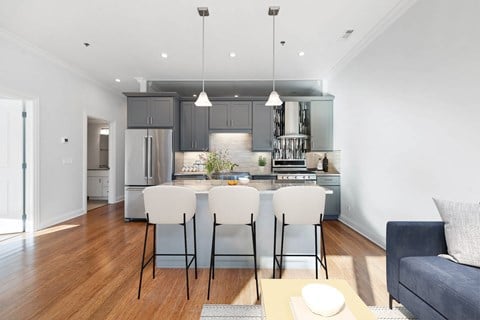 A modern kitchen with a dining table set for two.