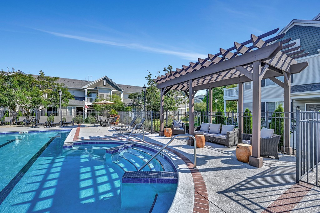 Farmington Lakes community swimming pool surrounded by a pergola with lounge seating