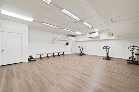 A gym with wooden floors and exercise bikes.