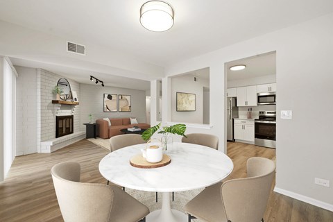 A modern dining room with a white table and chairs.
