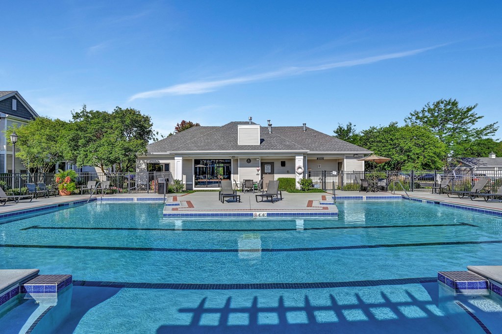 large swimming pool with lap lanes outside the Farmington Lakes Apartments clubhouse