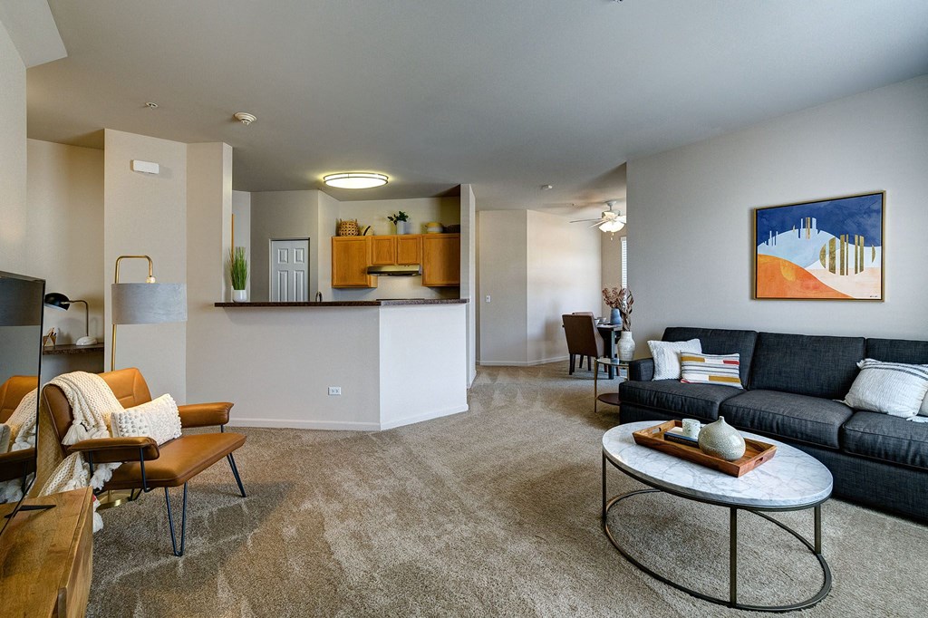 living room with a gray sofa, oval coffee table, and tv console