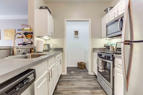A kitchen with white cabinets and stainless steel appliances.