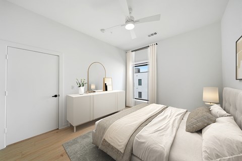 A bedroom with a large bed and a dresser with a mirror.
