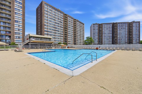 A swimming pool in front of apartment buildings.