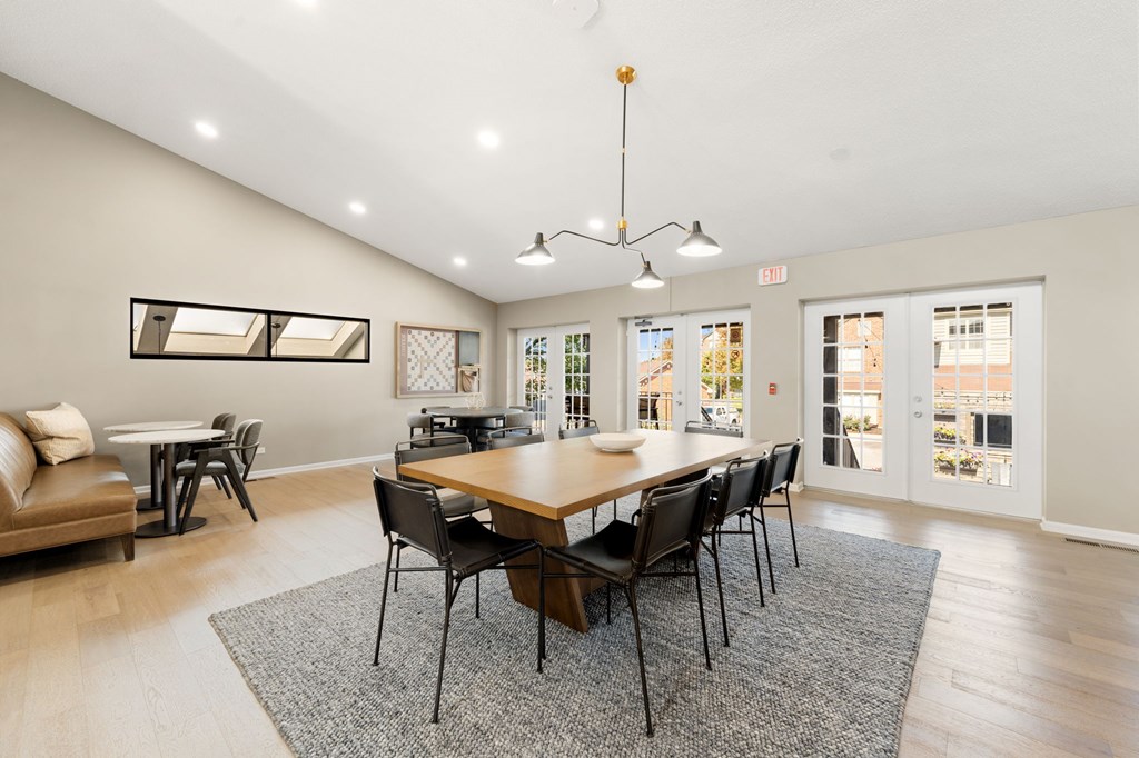 A dining room with a large table and chairs.