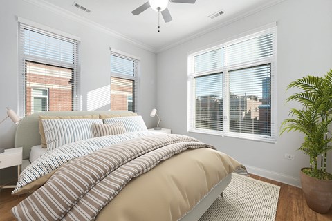 A bedroom with a large bed and a ceiling fan.