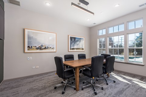 A conference room with a large table and chairs.