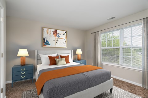 A bedroom with a bed, two nightstands, and a painting on the wall.