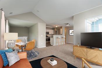 A living room with a couch, chairs, and a television.