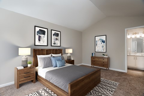 A bedroom with a bed, nightstands, and pictures on the wall.