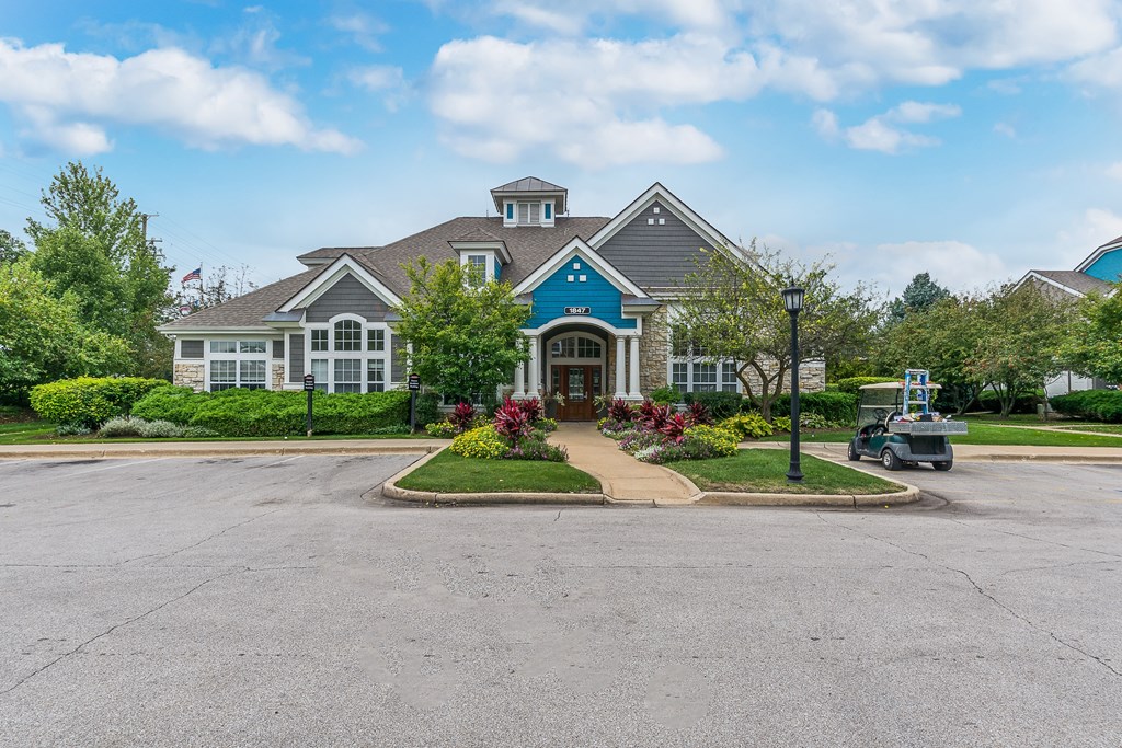 A large house with a grey roof and a blue trim.