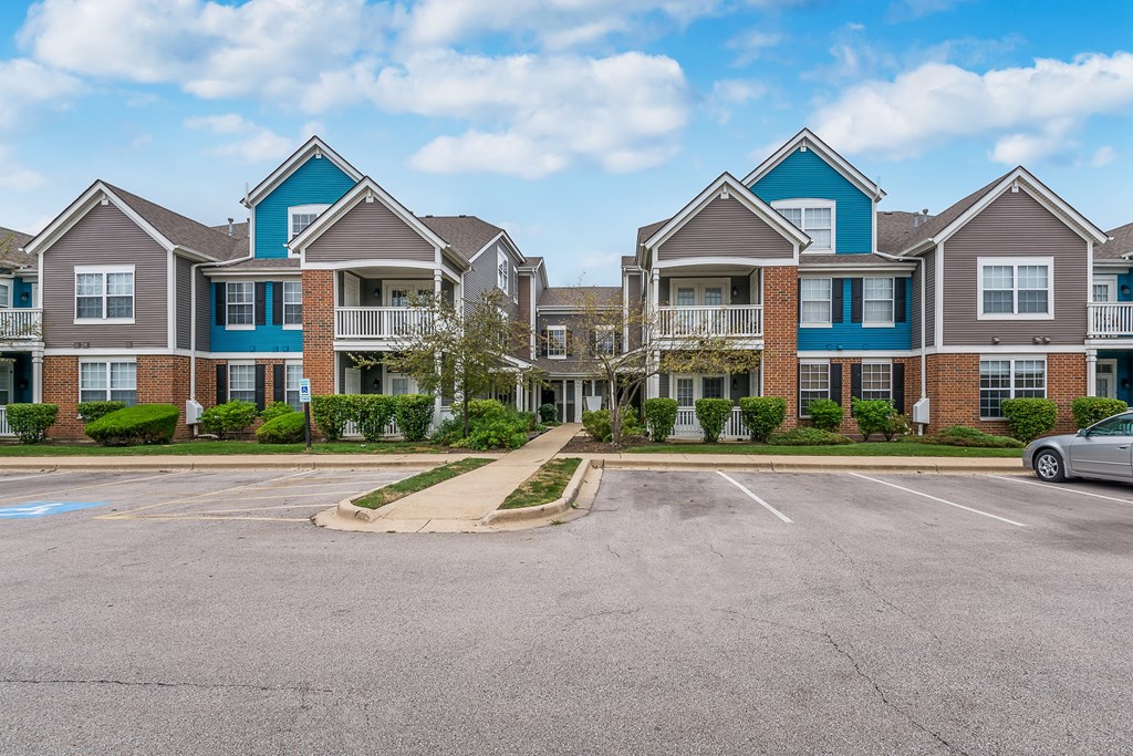 A large building with a parking lot in front.