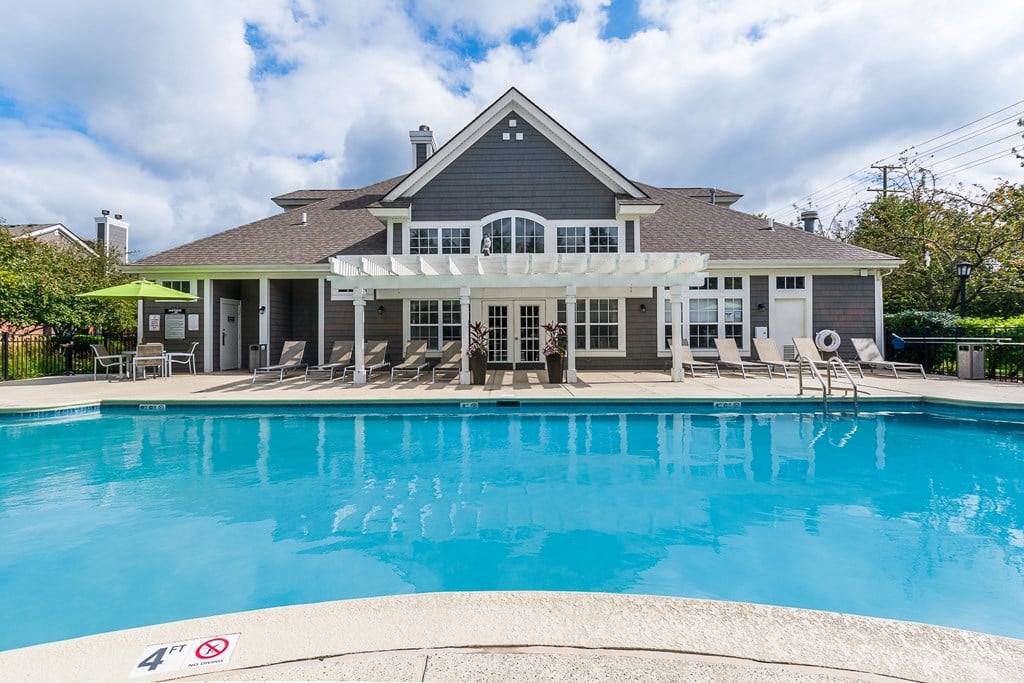 A house with a pool in front of it.