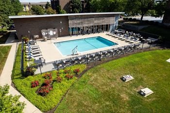 game lawn next to a fenced-in swimming pool at Willing Crossing Apartments in Elk Grove Village