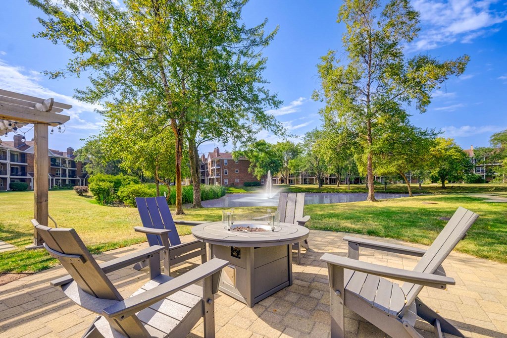 A patio with a table, chairs, and a fountain.