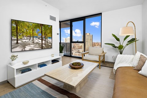 A living room with a large painting of a beach scene on the wall.