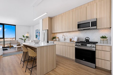 A modern kitchen with wooden cabinets and a black stove top oven.